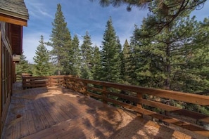 A wooden deck with a railing, surrounded by tall pine trees. - Atkin 4 Bedroom Holiday Home By Tahoe Truckee (Truckee)