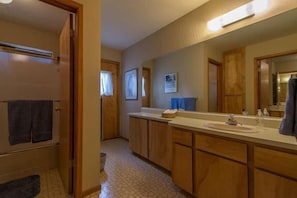 A bathroom with wooden cabinets, a large mirror, and a sink. - Atkin 4 Bedroom Holiday Home By Tahoe Truckee (Truckee)