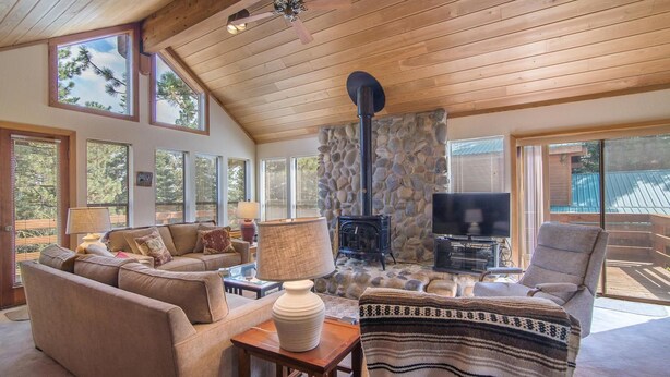 A cozy living room with a stone fireplace, a television, and comfortable seating.
