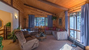 A cozy cabin interior with a wooden ceiling, a sofa set, a chair, and a coffee table. - Gamara 3 Bedroom Holiday Home By Tahoe Truckee (Truckee)