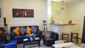 A living room with a black sofa, a coffee table, and a dining area with a table and chairs.
