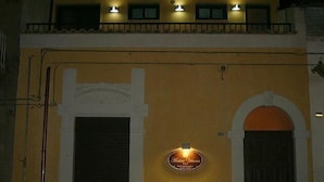 A building with a yellow facade, a large arched entrance, and a sign that reads "Hotel Vales."