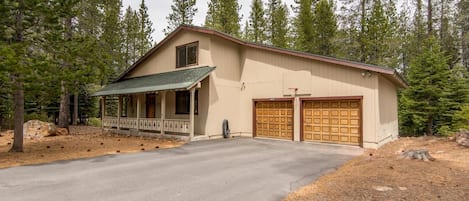 A two-story building with a covered porch, a garage, and a driveway.