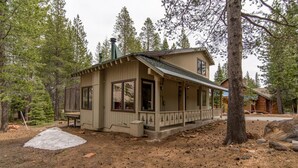 A cabin with a porch, surrounded by trees. - Kelly 3 Bedroom Holiday Home By Tahoe Truckee (Truckee)