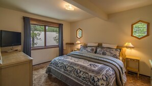A bedroom with a large bed, a television on a wooden stand, and a window with curtains. - Kelly 3 Bedroom Holiday Home By Tahoe Truckee (Truckee)