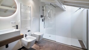 A modern bathroom with a large sink, bidet, and glass-enclosed shower. - 59 Steps Trevi (Rome)