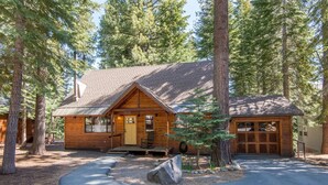 A cabin with a chimney, a garage, and a porch with a chair. - Saunders 3 Bedroom Holiday Home By Tahoe Truckee (Truckee)