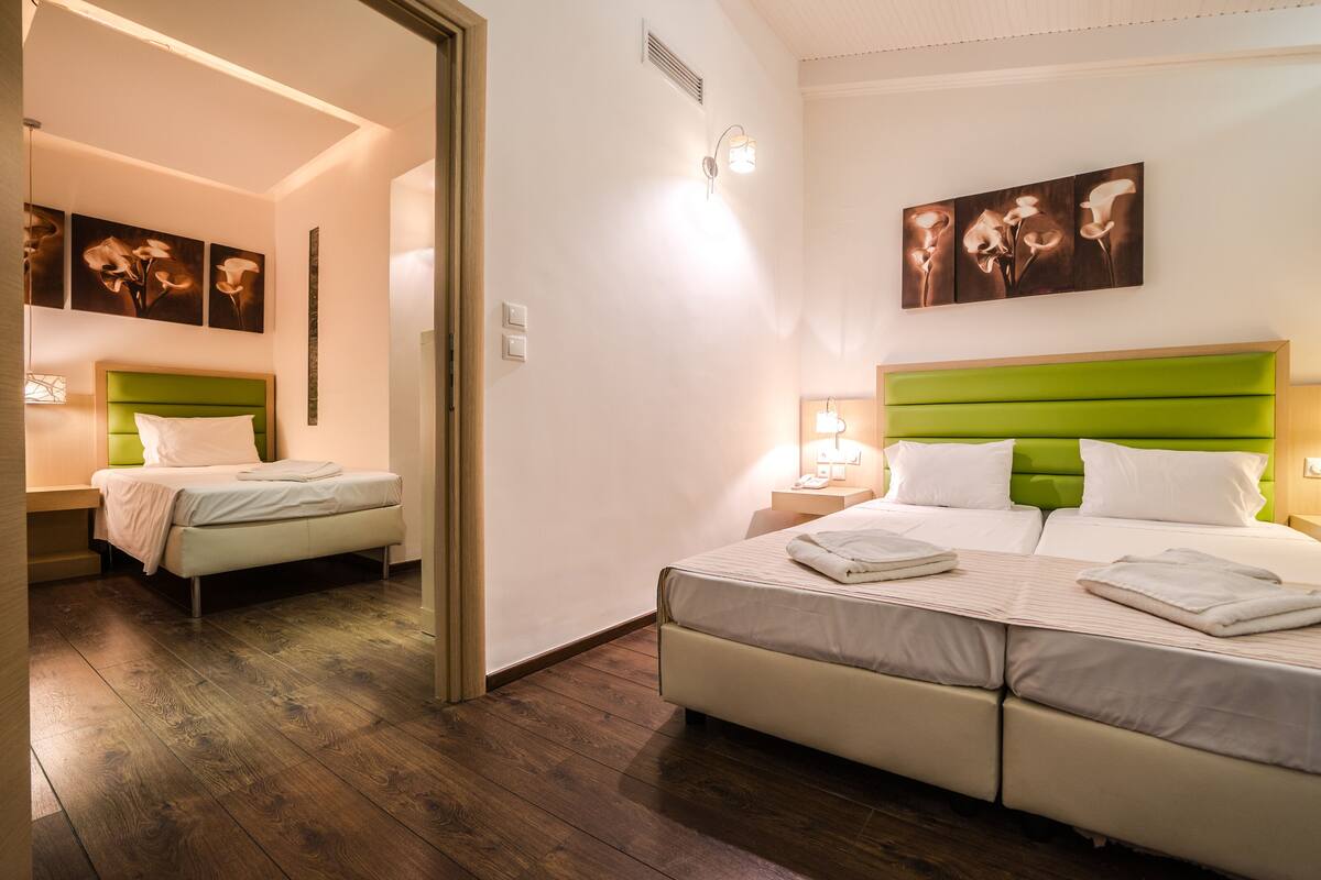 A hotel room with a large bed, two bedside tables, a mirror, and artwork on the walls.