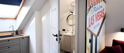A modern bathroom with a skylight, a sink, and a mirror.
