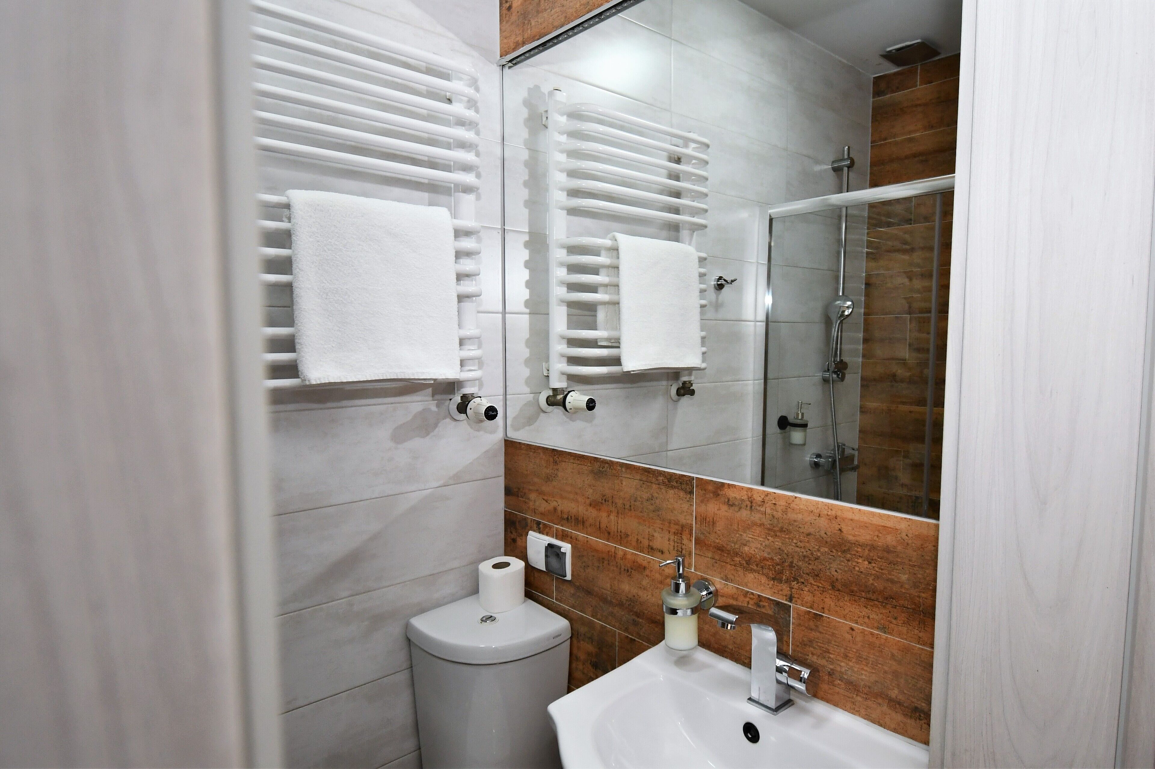 A modern bathroom with a toilet, sink, and shower.