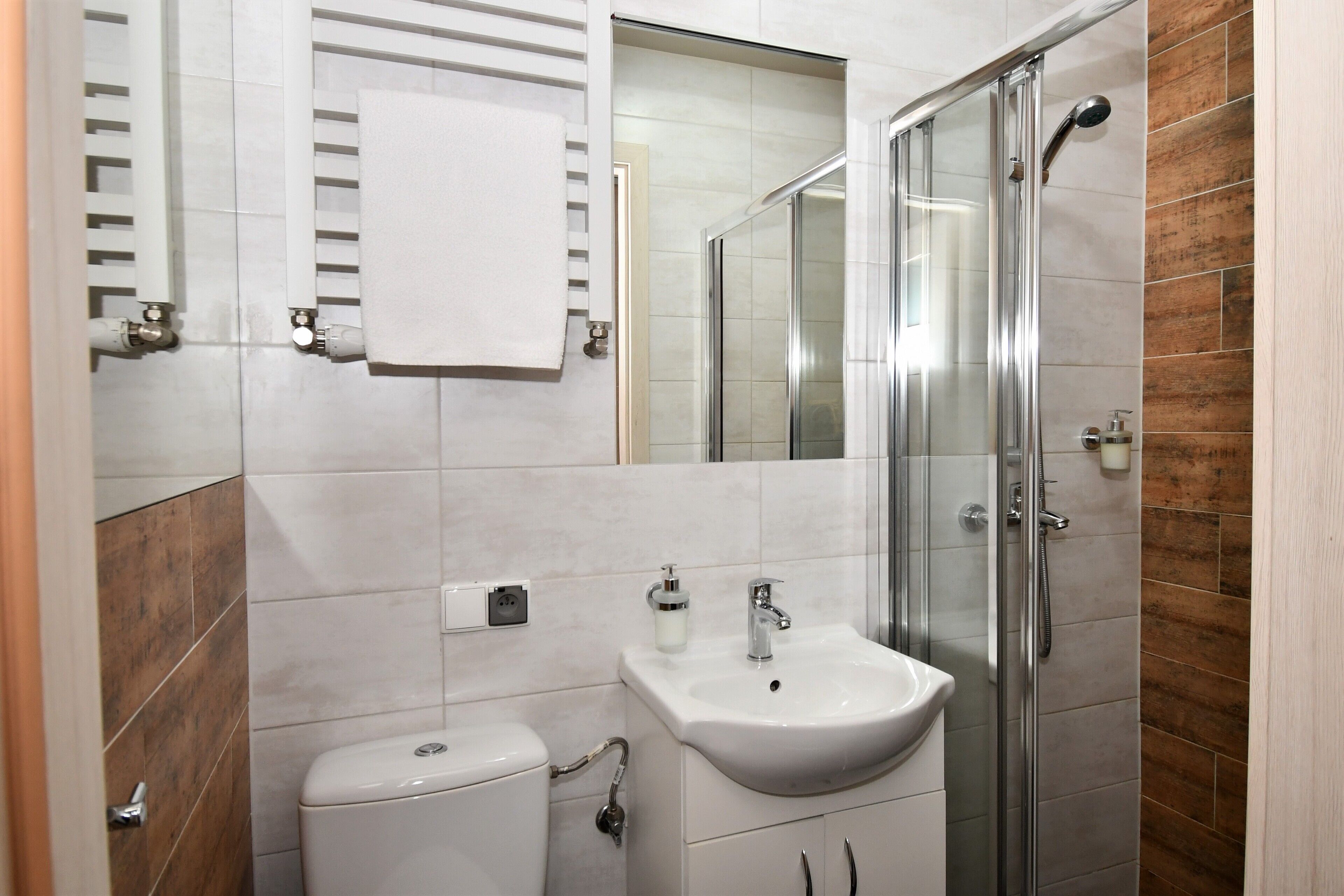 Ein modernes Badezimmer mit Toilette, Waschbecken und einer gläsernen Duschkabine.