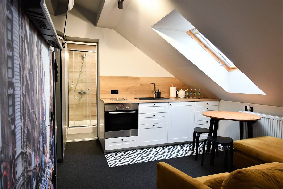 Una cocina moderna con tragaluces, horno empotrado y comedor con mesa y sillas.