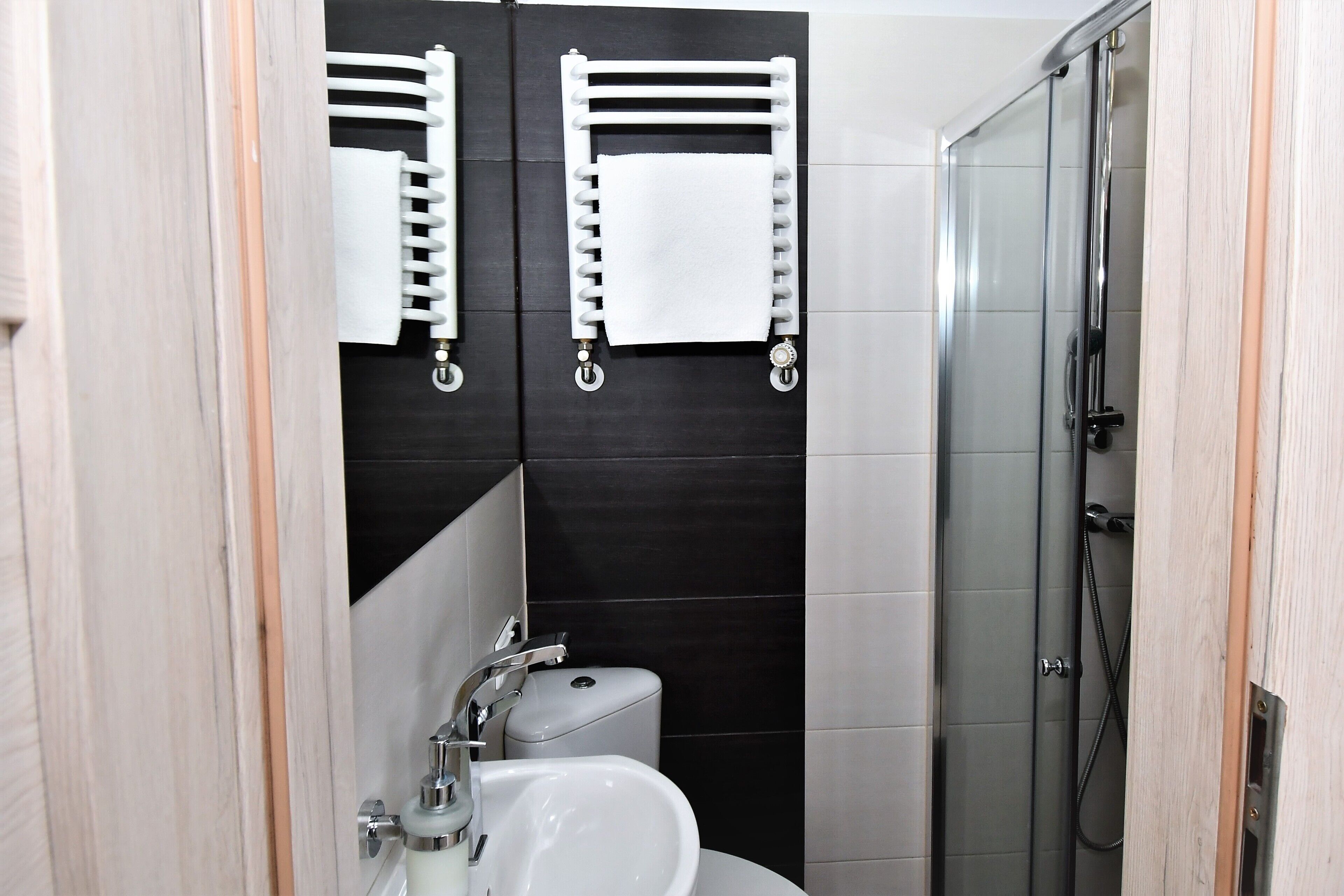 A bathroom with a white sink, a toilet, and a glass-enclosed shower.