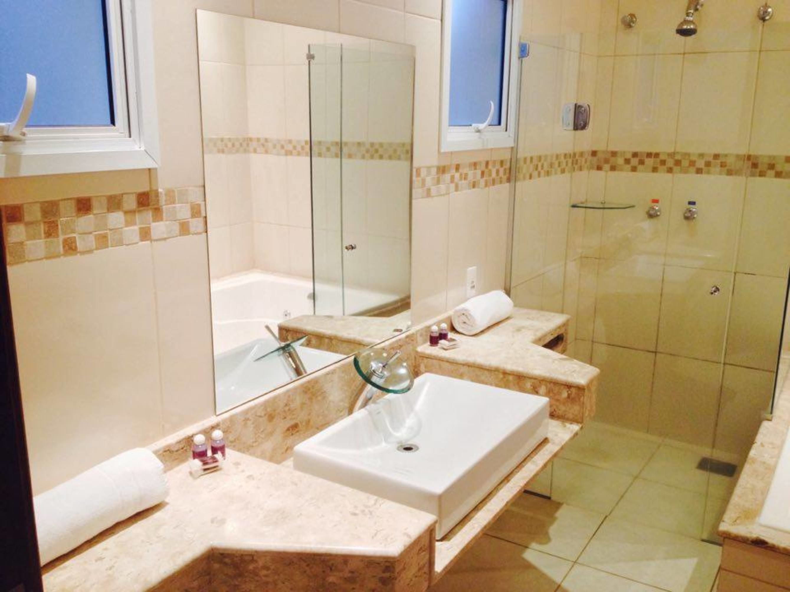 Ein modernes Badezimmer mit zwei Waschbecken, einem großen Spiegel und einer Duschkabine.