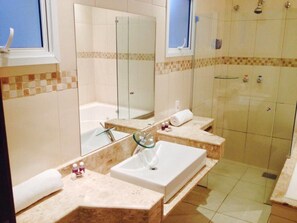 A modern bathroom with two sinks, a large mirror, and a shower area. - Habitat Hotel Pirassununga (Pirassununga)