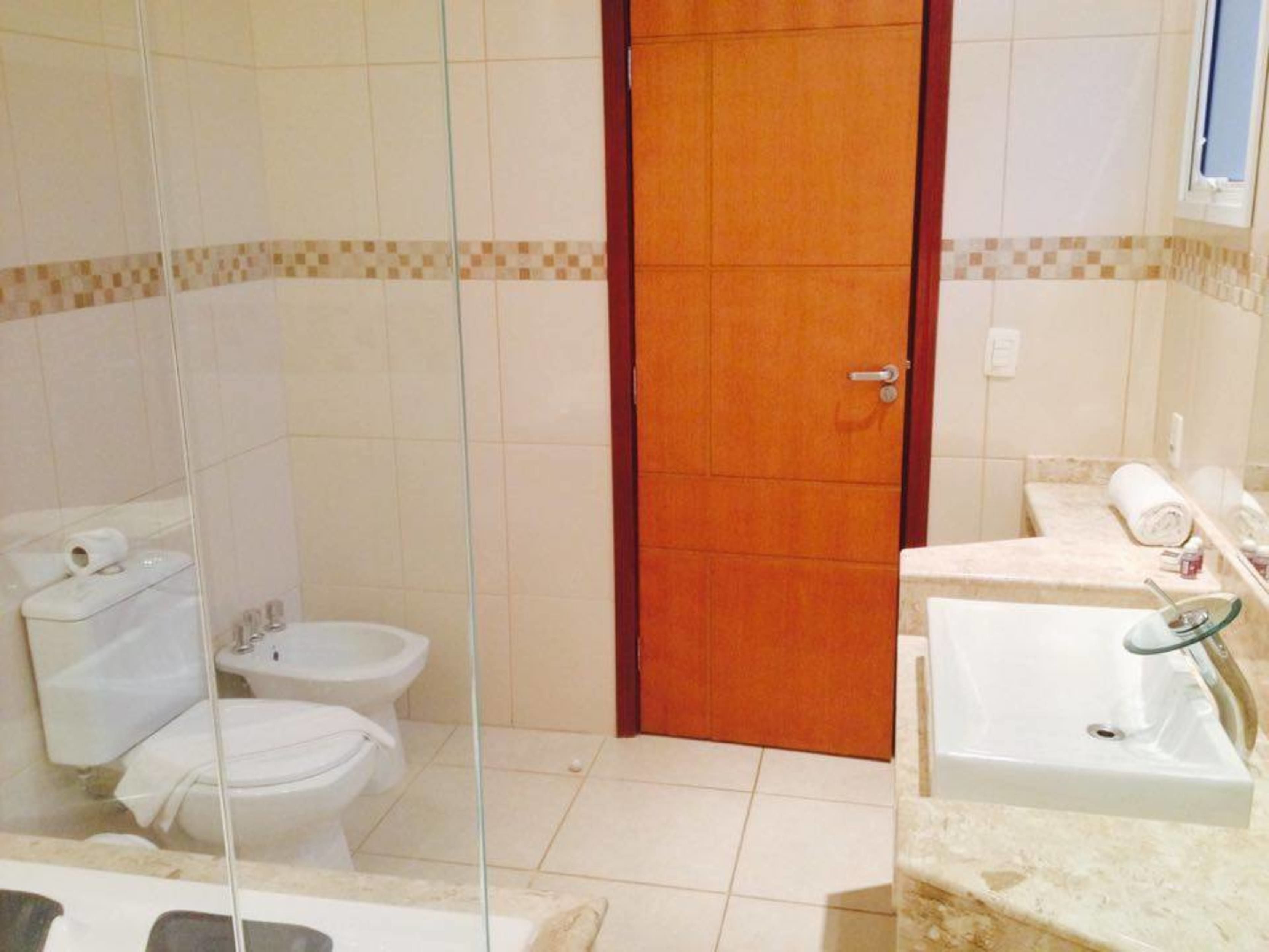 A bathroom with a toilet, bidet, and sink.