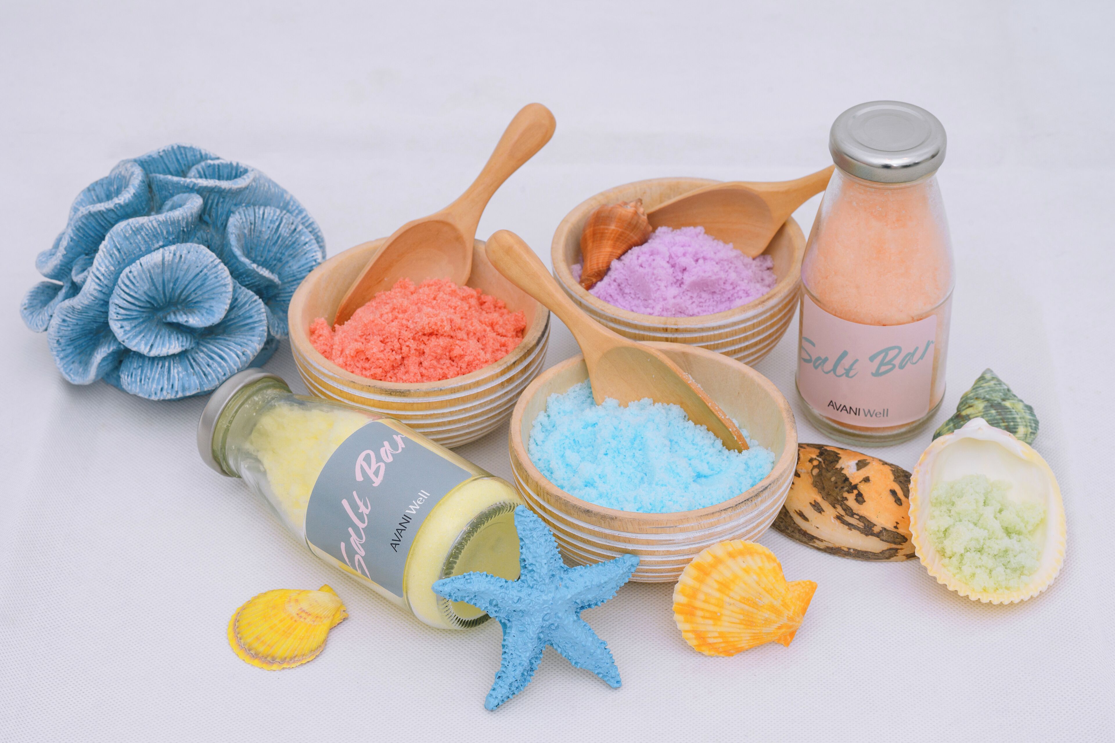 A collection of bath salts, starfish, and seashells arranged on a table.