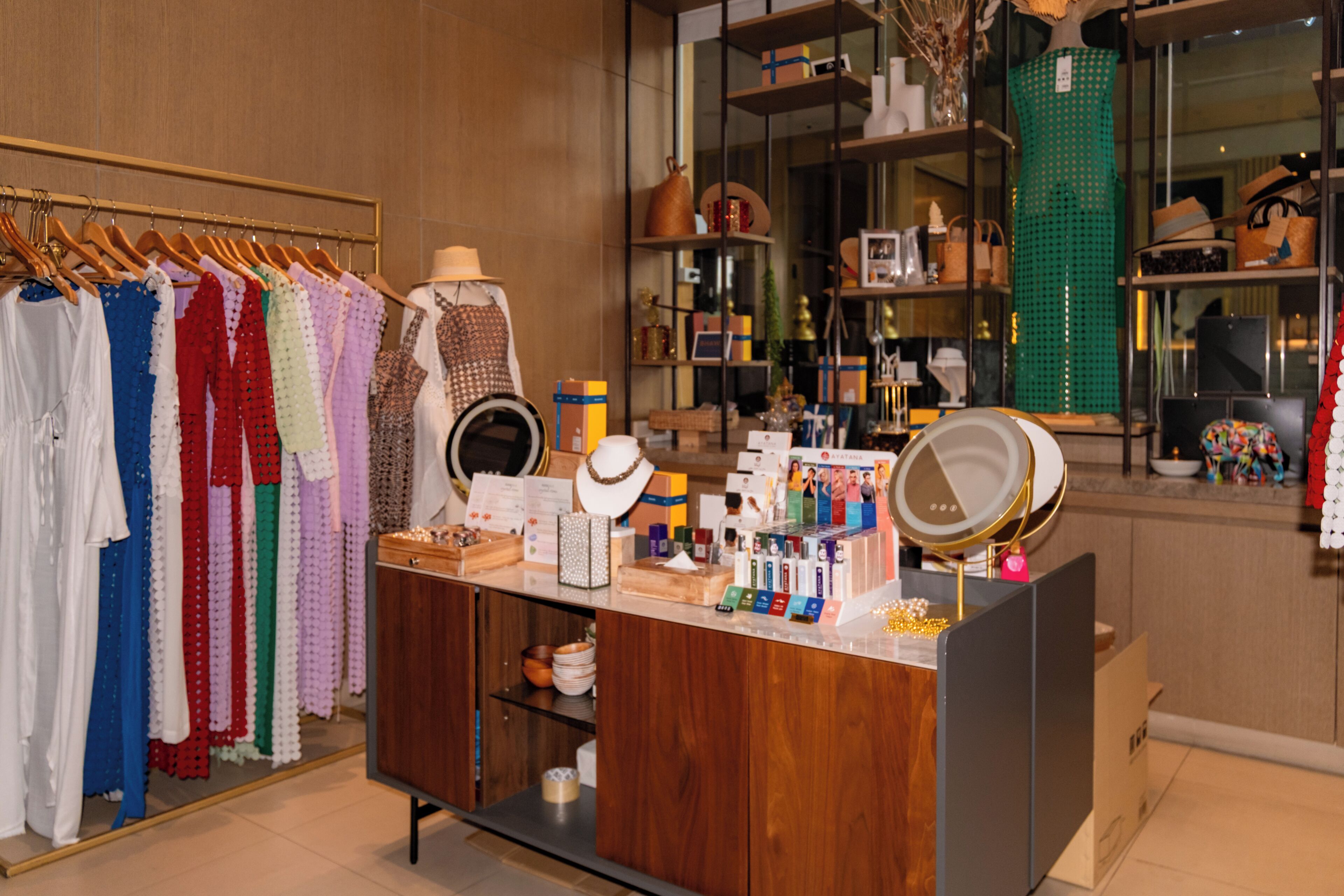 A boutique hotel room with a wooden vanity, a mirror, and a variety of toiletries.