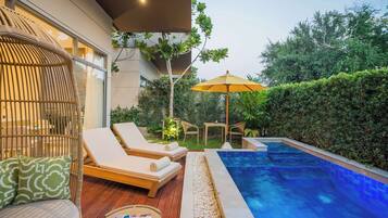 Relax by the well-maintained pool surrounded by a deck and lounge chairs with cushions.
