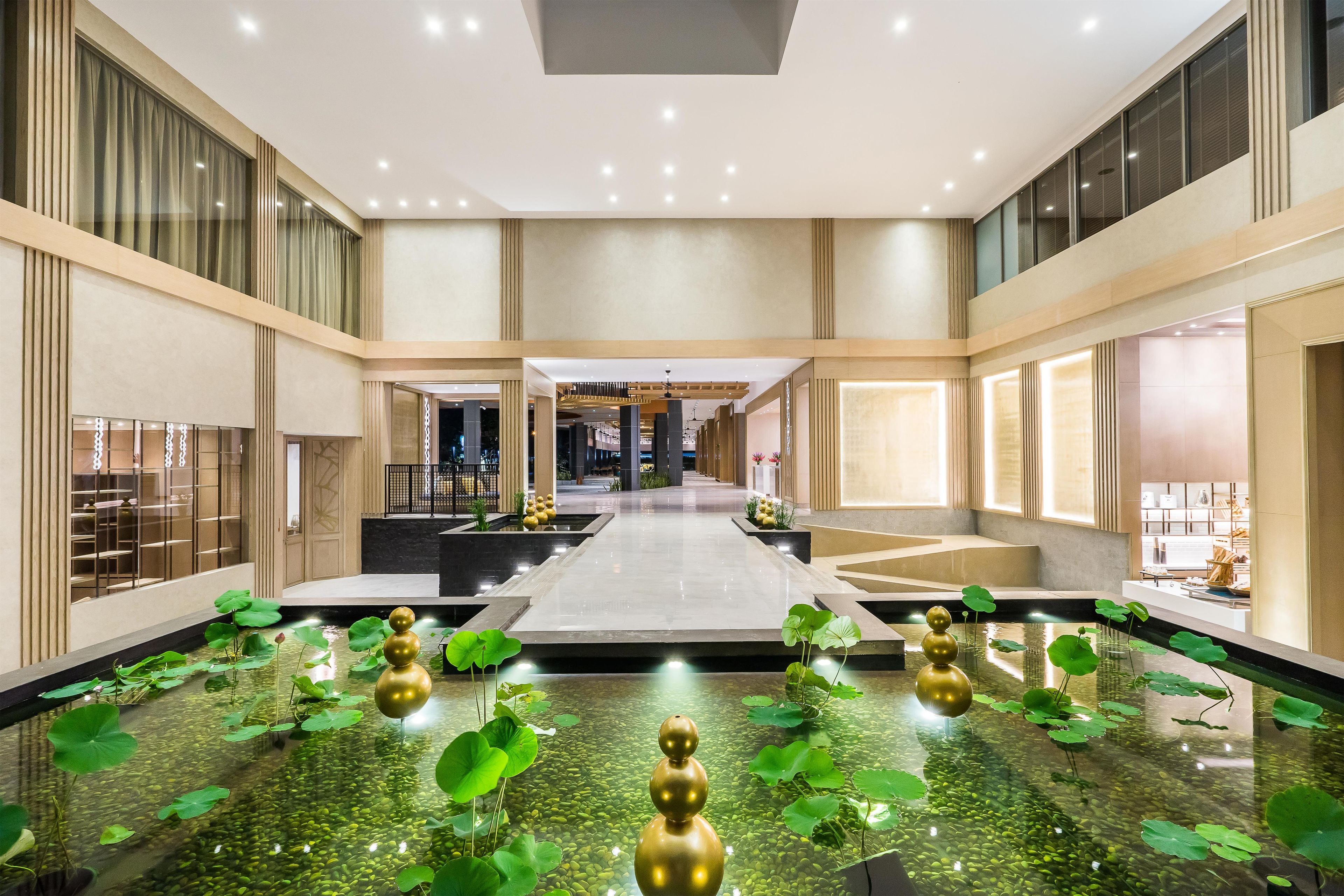 A spacious atrium with a central water feature, surrounded by seating areas and a view of the hotel's interior.