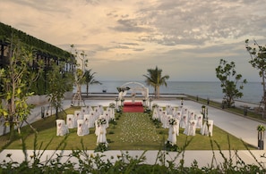 Exchange vows with breathtaking ocean views as a lush green backdrop and elegant arch set the scene for a romantic ceremony.