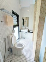 Un baño moderno con inodoro, ducha y lavamanos.