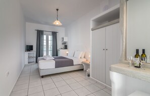 A modern bedroom with a bed, bedside table, TV, and a wardrobe. - Villa Sosanna (Milos)