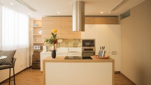 Una cocina moderna con armarios de madera, una isla central y una campana extractora de acero inoxidable.