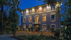A two-story building with a balcony, potted plants, and outdoor seating. - Resort Dei Limoni (Lucca)