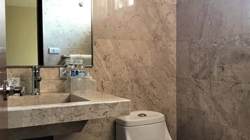 A bathroom with a marble sink, a toilet, and a towel rack.