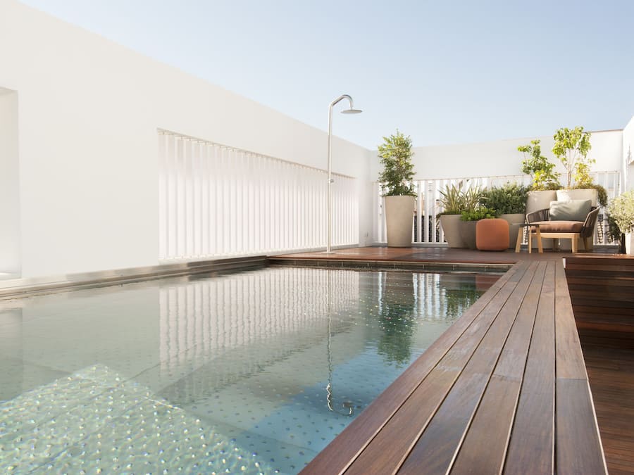 Een buitenzwembad, parasols voor strand/zwembad