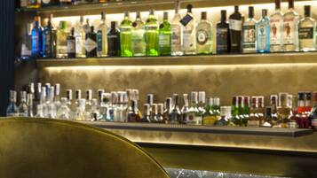 Un bar amb amples prestatges plens de botelles de licors diversos.