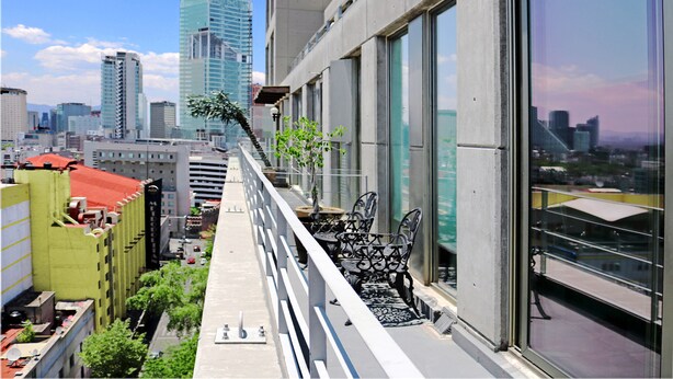 Un edificio de gran altura con amplias ventanas que dan a un paisaje urbano.