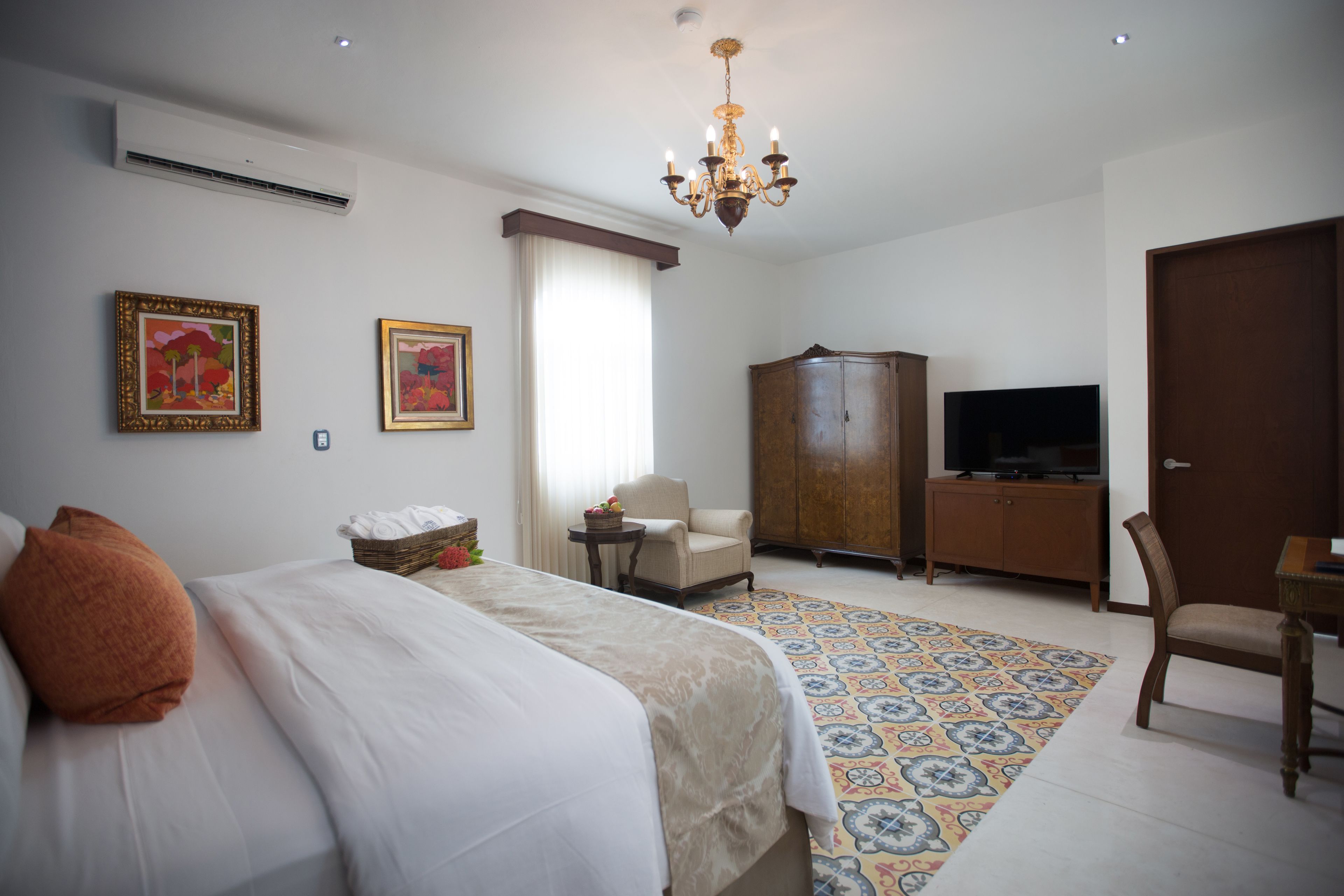 Una habitación de hotel con una cama, televisión, armario y una silla.