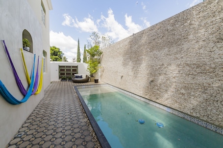 Una piscina al aire libre, sillones reclinables de piscina