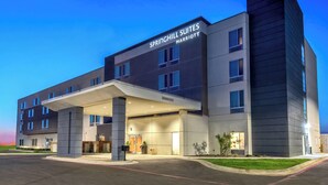 Un hôtel moderne doté d’une entrée couverte, de plusieurs étages et d’une enseigne indiquant « Springhill Suites Marriott ».