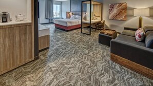 Une chambre d’hôtel comprenant un lit, un bureau et un coin salon.