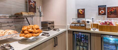 A breakfast buffet with various pastries, bread, and dairy products.