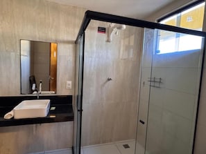 A modern bathroom with a glass shower enclosure, a white sink, and a large mirror. - Hotel Pousada Elo Inn (Jaboatão dos Guararapes)