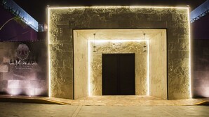 A stone entrance with a lit frame, a sign reading "La Morada Boutique Hotel & Spa", and a palm tree in the background.
