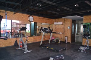 Un gimnasio con equipo de ejercicio, un reloj y un espejo.
