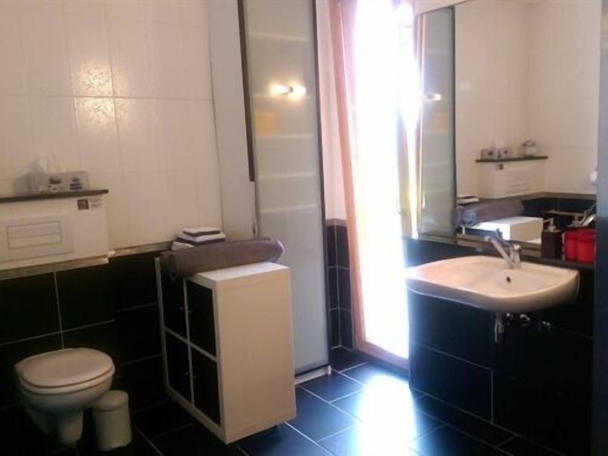 Een badkamer met toilet, wastafel en douche.