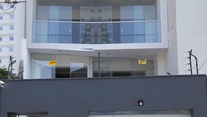 Un edificio de varios pisos con un diseño arquitectónico moderno, que cuenta con balcones y ventanas amplias.