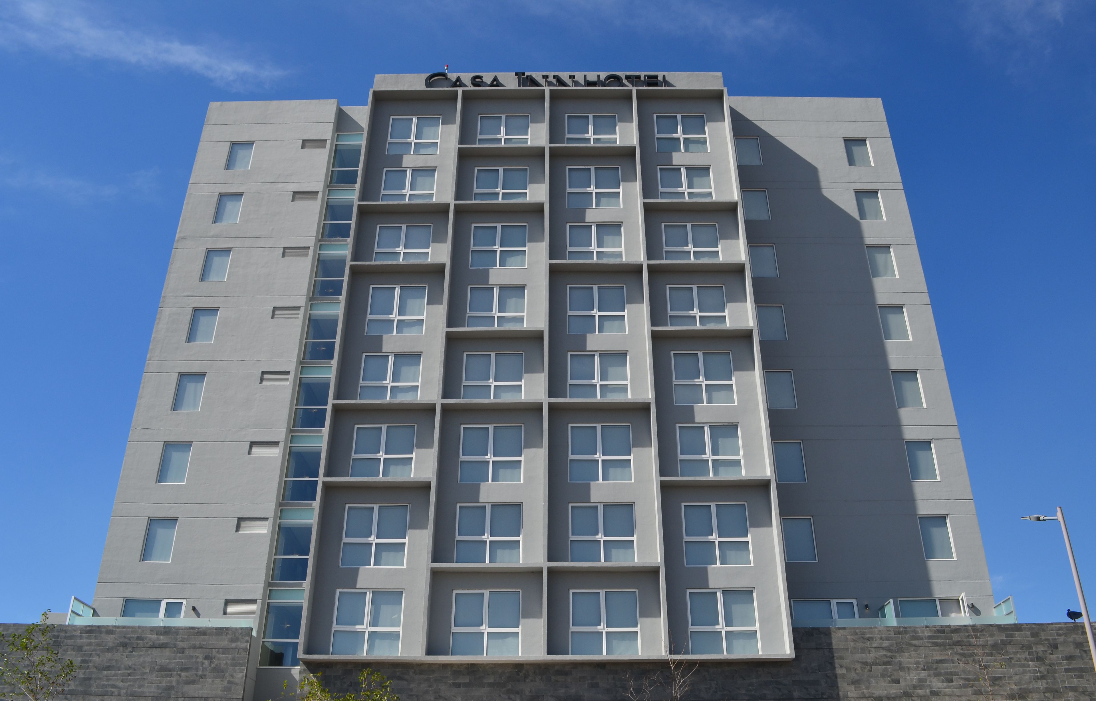 A multi-story hotel with a modern design, featuring a prominent name at the top.