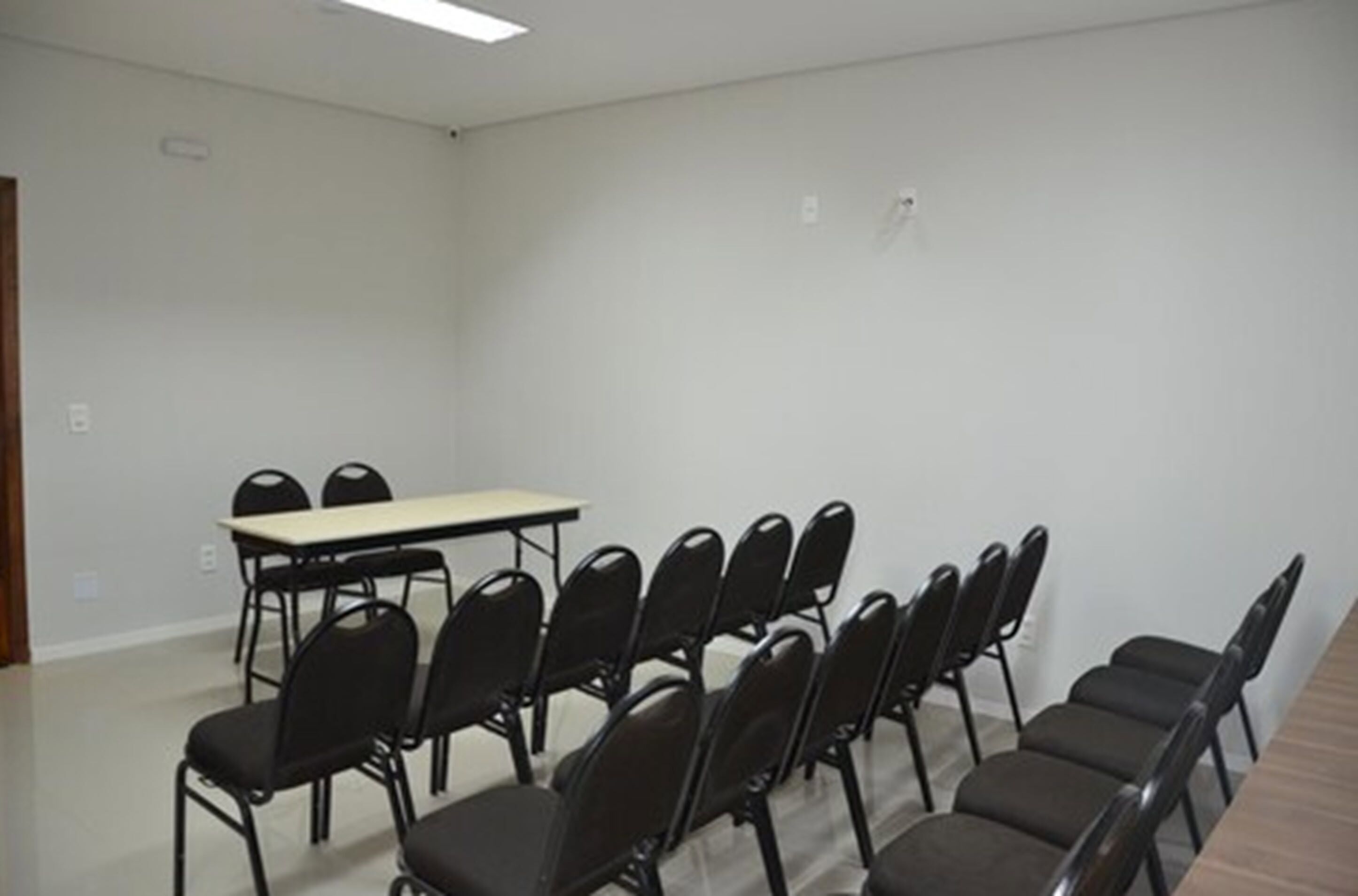 A conference room with a long table and multiple chairs.