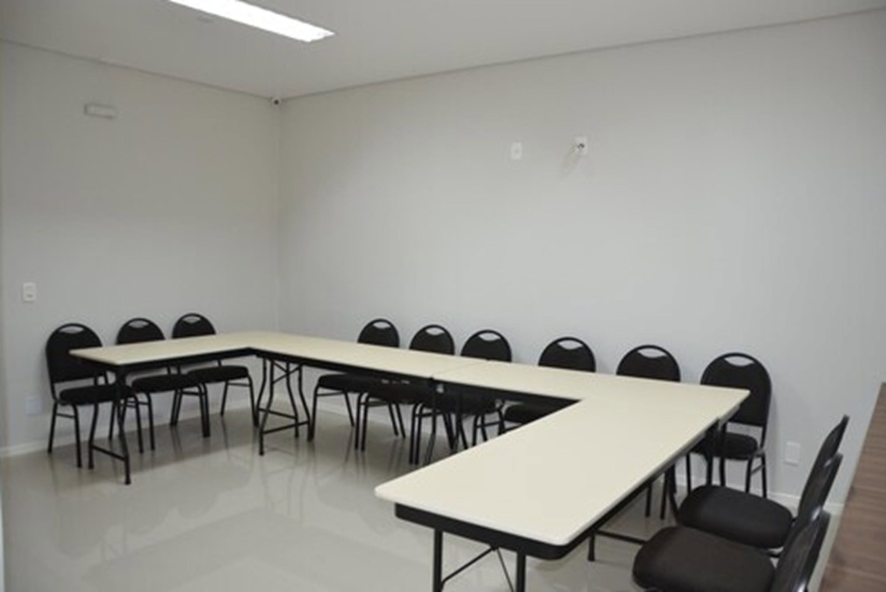 Uma sala de conferência com uma mesa comprida e várias cadeiras.