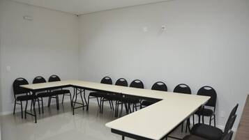 Uma sala de conferência com uma mesa comprida e várias cadeiras.