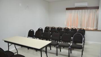 A conference room with a long table and rows of chairs.