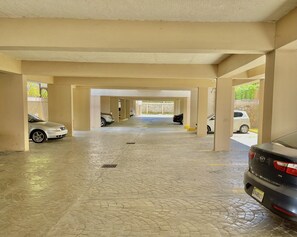 A covered parking area with multiple cars parked under a roof structure. - Punta Cana Seven Beaches (Punta Cana)