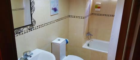 A bathroom with a toilet, sink, and bathtub.